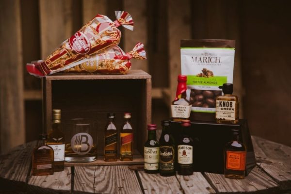 Variety of whiskey bottles and chocolates on a wooden crate for a gift idea